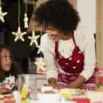 girl baking cookies with help of her mom
