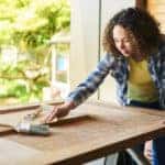 a woman sands a vintage wooden door