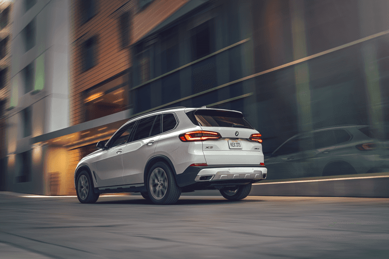 A white 2021 BMW X5 SUV driving in the city