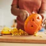 woman carving pumpkin