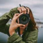 A young woman using a DSLR camera