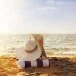 woman lying on beach and reading a book.