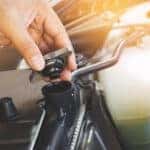 Don't Overlook Your Radiator & Cooling System -- Hand is opening the radiator cap to check the coolant level