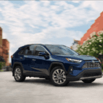 blue 2025 RAV4 parked in a downtown street - Driving Dynamics of the 2025 RAV4 Powertrains
