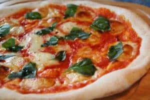 Image of a pizza topped with spinach from Olivio's.