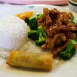 General Tso's Chicken on a plate with white rice and broccoli
