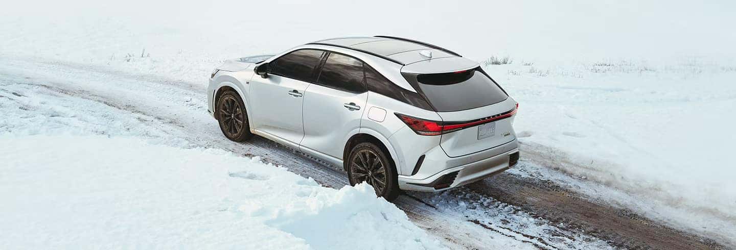 A Lexus RX navigating a winter road, displaying its all-wheel-drive capability and stylish exterior.