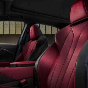 A close-up of the Lexus RX F Sport interior, highlighting red and black leather seats with F Sport badging.