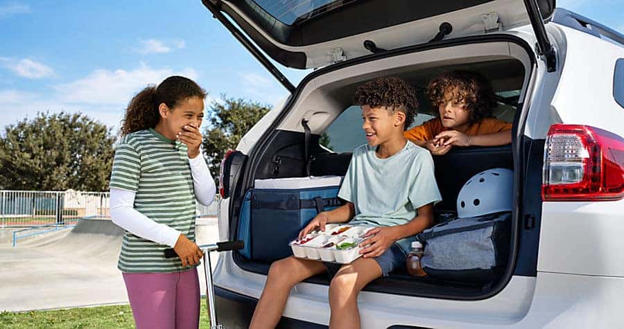 subaru ascent trunk open with kids sitting in to show cargo space