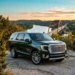 2026 GMC Yukon Denali in a deep metallic hunter green, parked on a scenic overlook in the Austin Texas Hill Country
