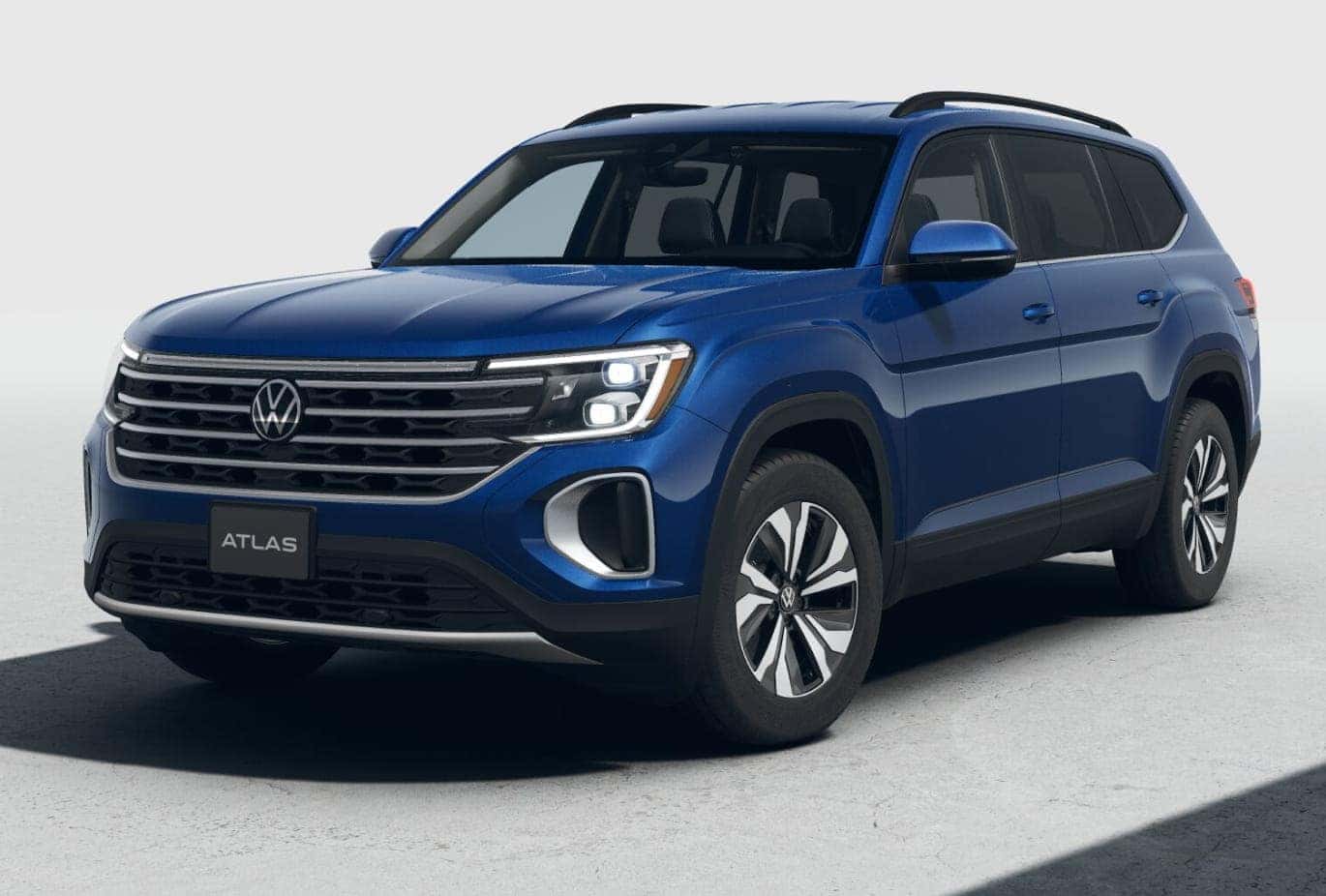 Blue 2026 Volkswagen Atlas shown from a front three-quarter view with LED headlights illuminated.