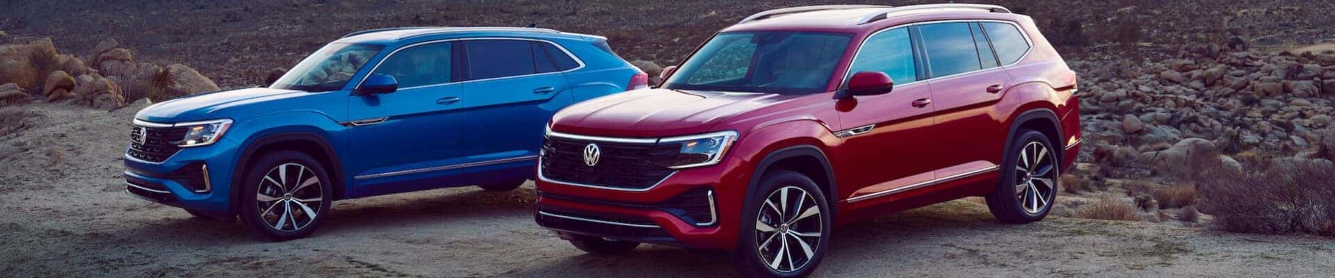 Two Volkswagen SUVs parked in a desert clearing at dusk.