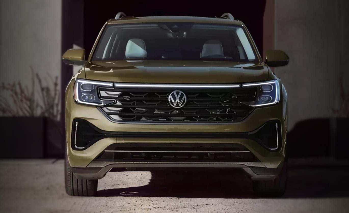 Front view of a 2026 Volkswagen Atlas with illuminated LED headlights and grille lighting.
