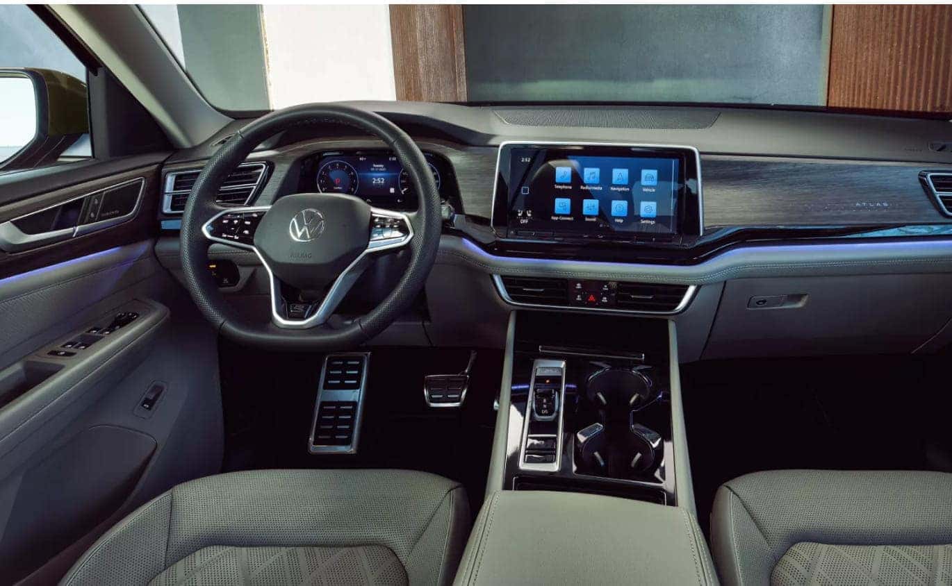 2026 Volkswagen Atlas interior featuring a digital instrument cluster, touchscreen display, and ambient dashboard lighting.
