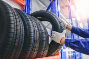 Four sturdy tires lined up on a showroom floor. The tires have deep treads for good grip. You can see different patterns for various weather conditions. The tires look durable and ready for daily use by busy professionals.
