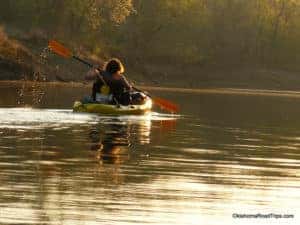 A person rowing a kayak down the river.