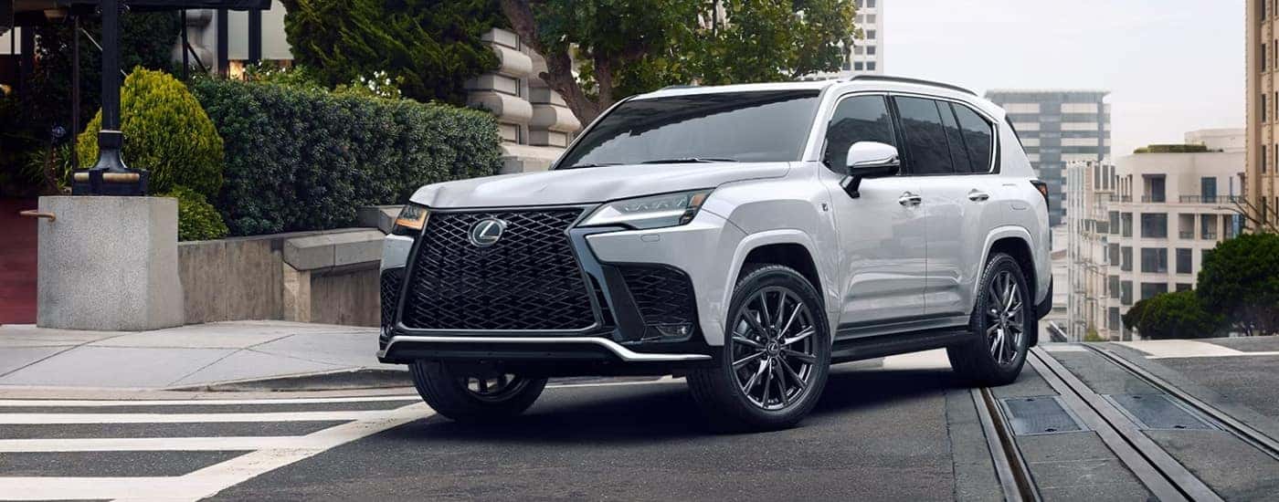 Silver 2026 Lexus LX Hybrid driving to a Lexus dealer