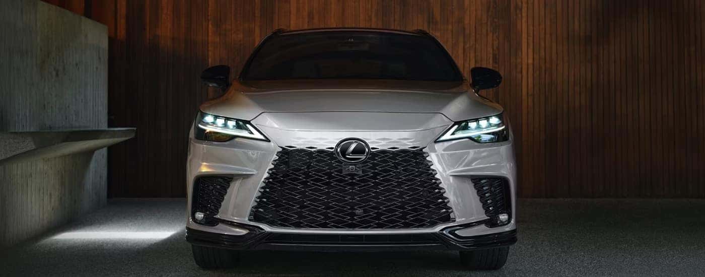 Silver 2026 Lexus RX parked in front of a slat wall