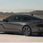 Rear profile of a dark gray 2026 Lexus ES sedan with mountains in the background.