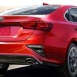 red kia forte driving on highway