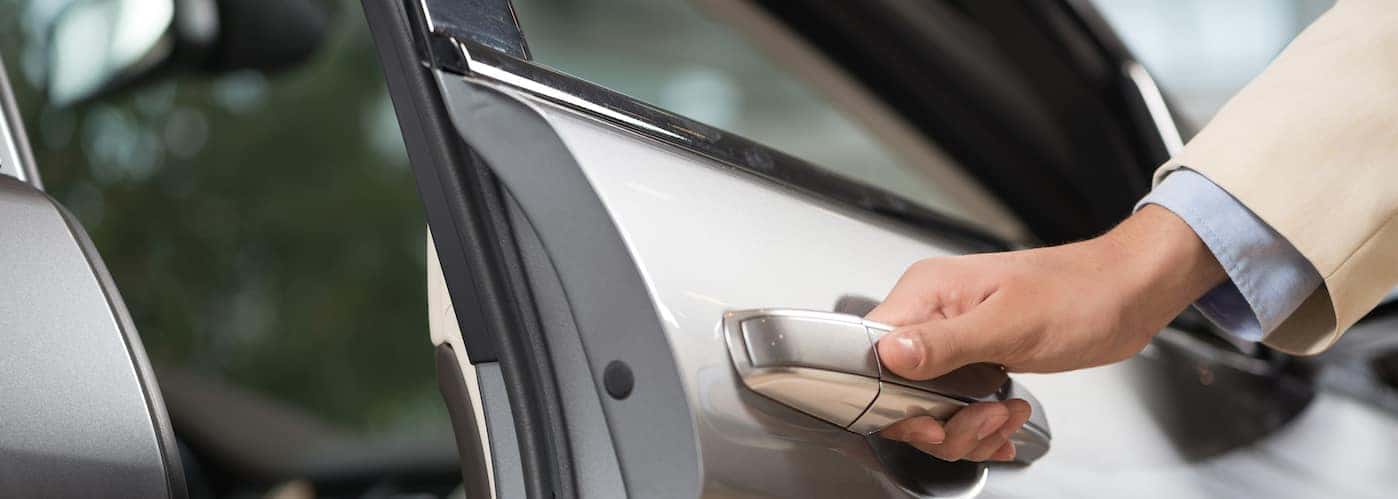 Salesperson's hand opening car door