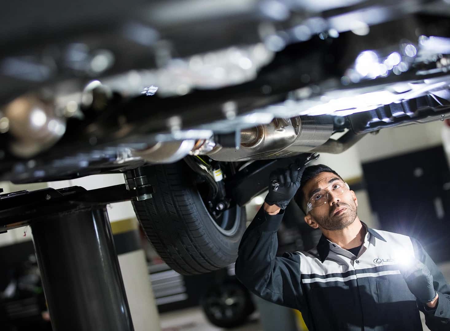 Lexus service tech looking under a car