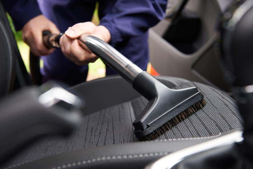 Worker vacuuming car