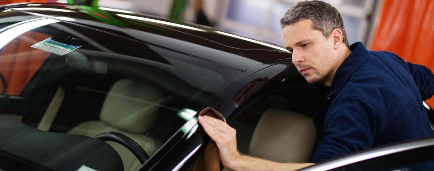 worker auto detailing a car