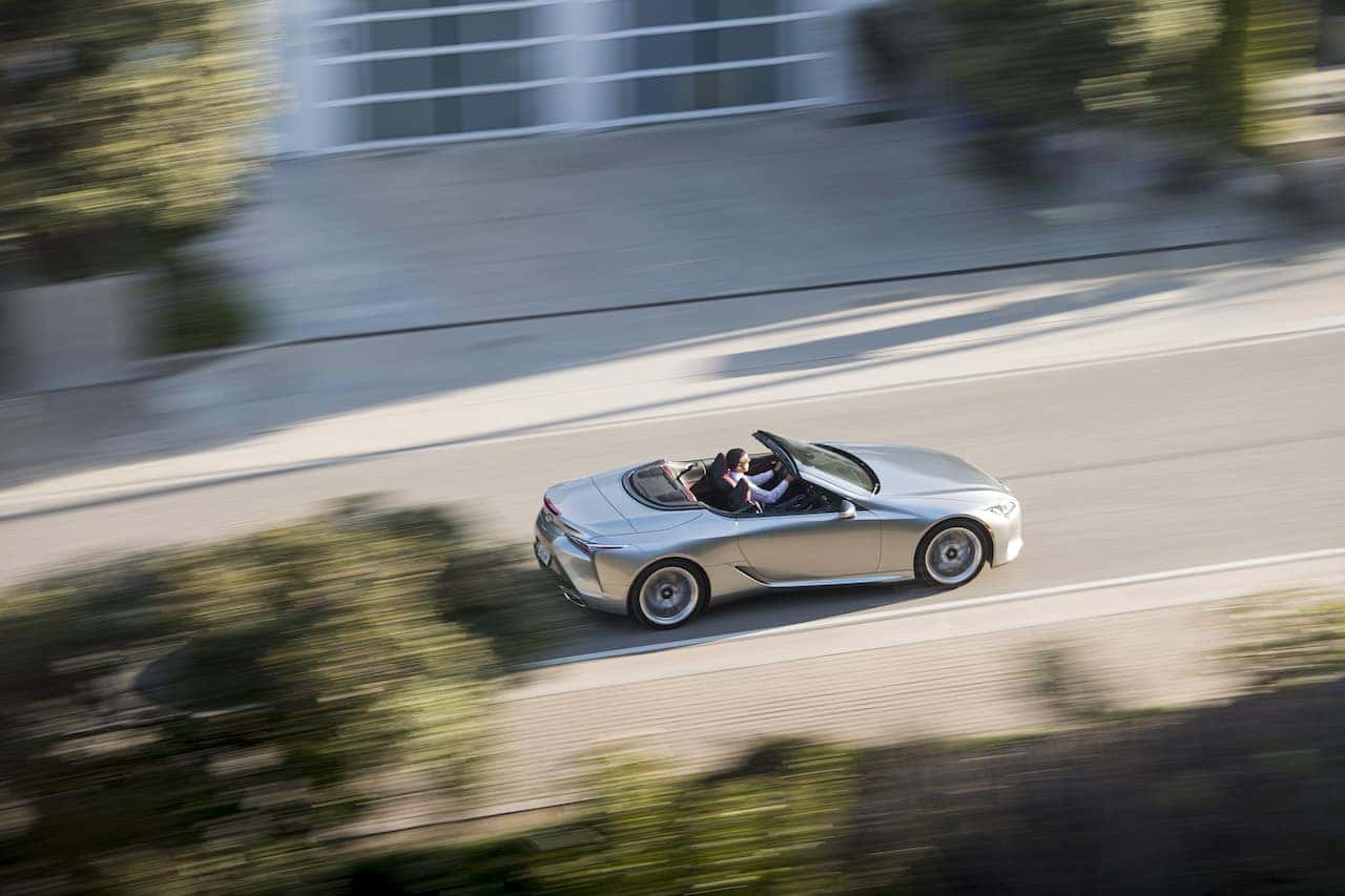 Silver Lexus LC 500 Convertible driving down a street