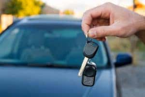 A hand holding keys from a car