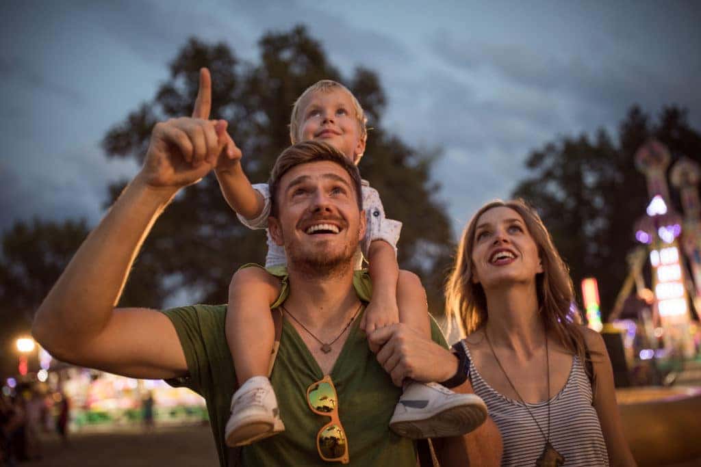 Family with one child outdoors on summer festival.