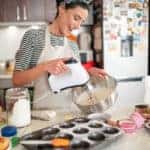Confectioner woman making delicious cream for cupcakes