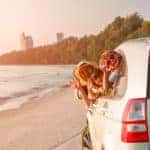 Car Cleaning Hacks After Summer Adventures - amily in the car leaving the sandy beach
