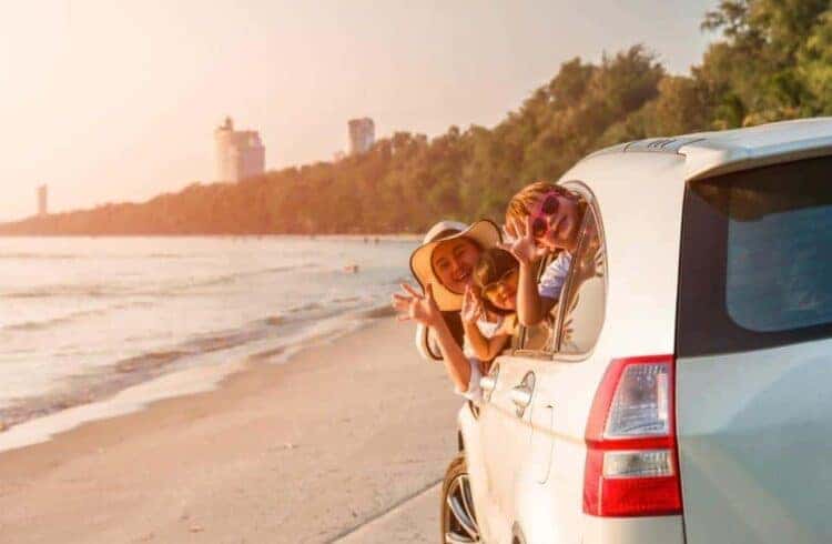 Car Cleaning Hacks After Summer Adventures - amily in the car leaving the sandy beach
