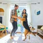 Couple dancing with pet dog in minimalist living room