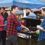 Group Of Sports Fans Tailgating In Stadium Car Park