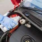A auto technician refills brake fluid reservoir