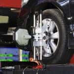 Car wheel fixed with computerized wheel alignment machine clamp.