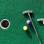 golf clubs and balls on putting green