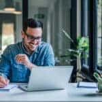 Carpe Diem: Seize the Day, Not the Stress -- Cheerful adult man with glasses, taking notes on the conference call.