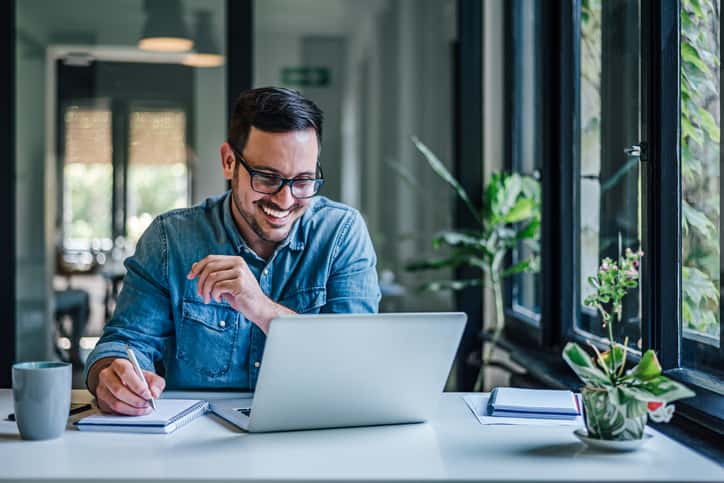 Carpe Diem: Seize the Day, Not the Stress -- Cheerful adult man with glasses, taking notes on the conference call.