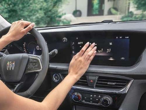 2025 Buick Encore GX view of woman using touchscreen display