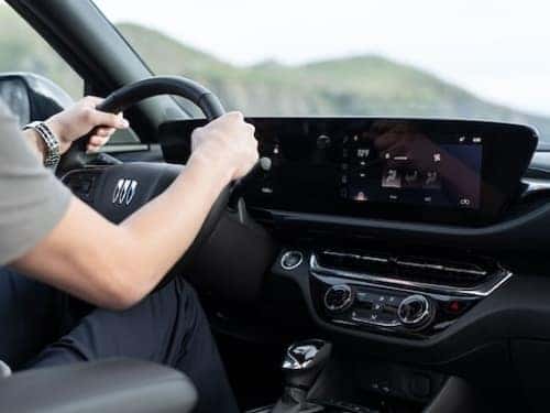 2025 Buick Envista front view of dash and person in driver's seat with hands on steering wheel