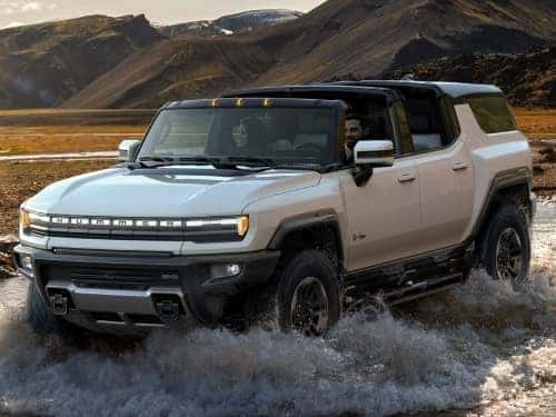 2025 Hummer EV SUV offroading through a stream