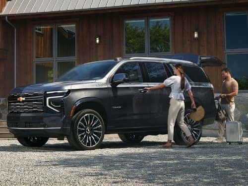 2025 Chevrolet Tahoe exterior view of vehicle with couple getting in and loading things into cargo area