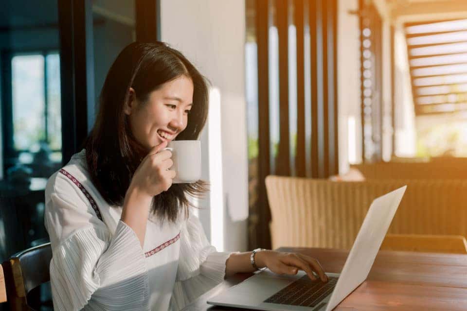 Woman online shopping at the kitchen table