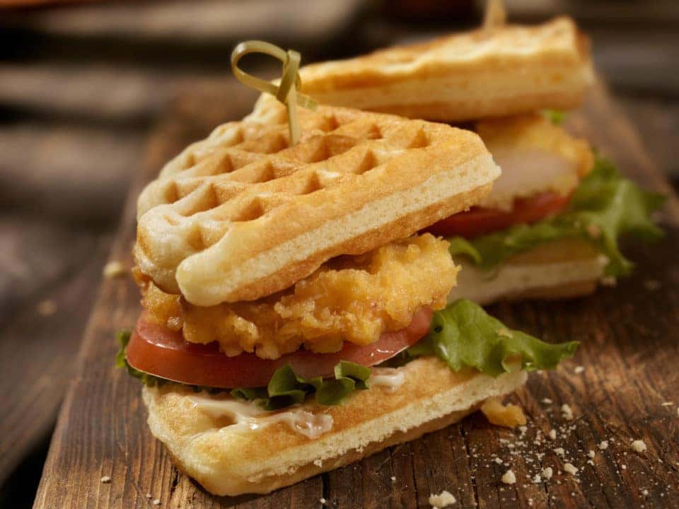 Fried Chicken and Waffle Sandwich with Lettuce and Tomato.