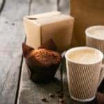 Coffee to go with muffin on wood background
