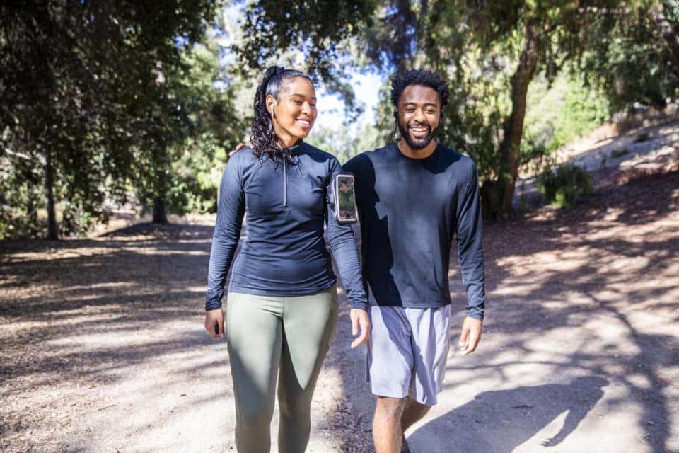 Man and woman walking on a trail after a workout