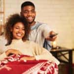 Couple watching movie with Christmas tree in the background